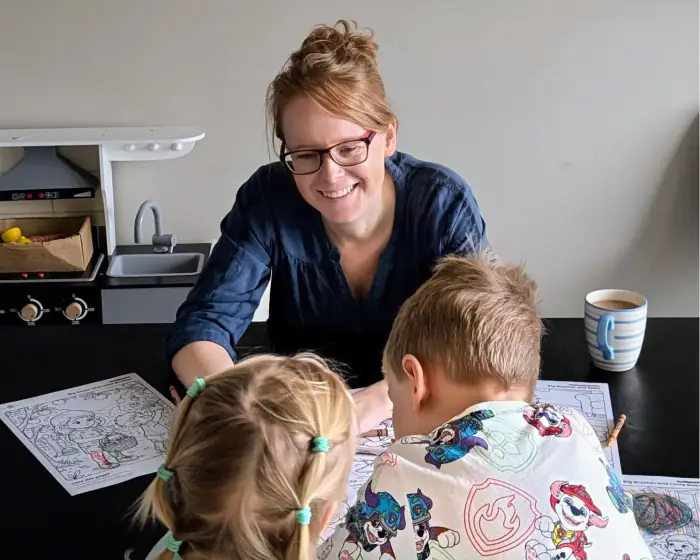 Sarah, founder of Happy Crayon Studios, colouring at the kitchen table with her two children